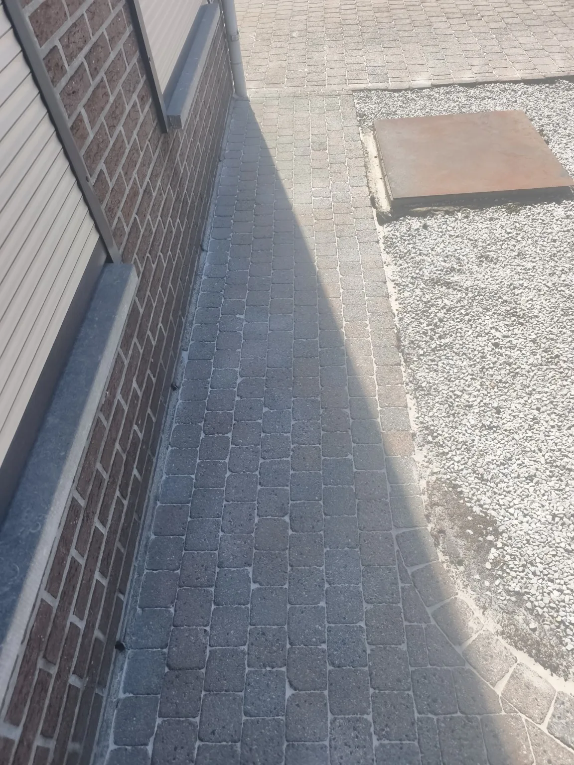 Gereinigd zijpad langs de woning na de behandeling